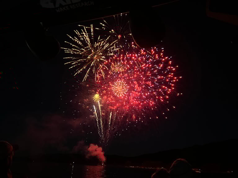 Red and gold fireworks bursting against a dark night sky with smoke trails